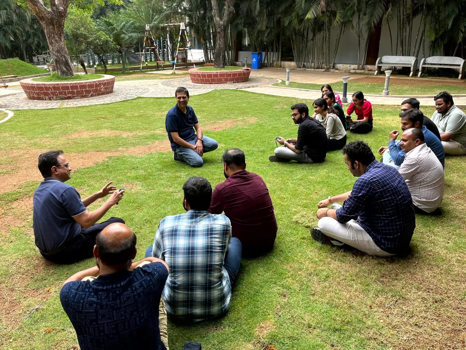 FusionFoundry team gathered in a circle on the grass at an offsite