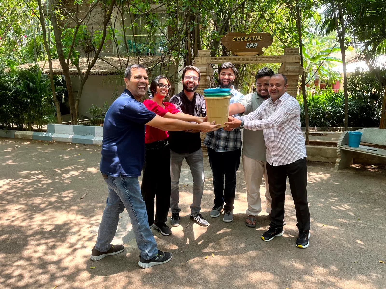 FusionFoundry team celebrating together with a stack of hands outdoors